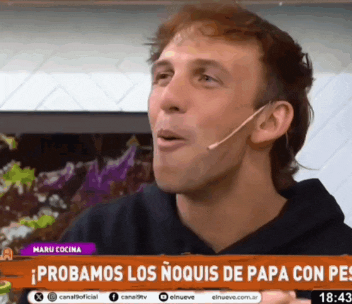 a man with a microphone in his ear is on a television screen with the words probamos los noquis de papa con pes