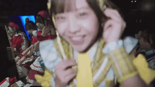 a girl wearing a yellow tie is smiling while standing in front of a mirror