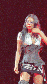a woman in a corset and a white shirt is dancing on a stage