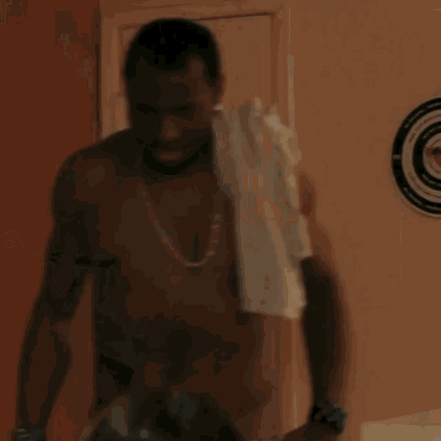 a shirtless man is drinking from a green bottle that says ' canadian ' on it