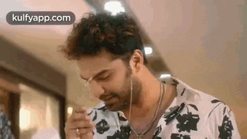 a man wearing earphones is eating a sandwich .