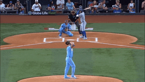 a baseball game is being played in front of a sign for globe life field