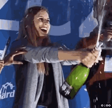 a woman is holding a bottle of champagne in her hands