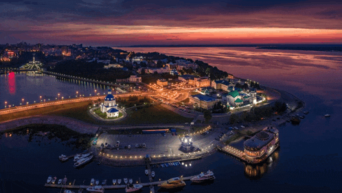 an aerial view of a city at night with boats docked