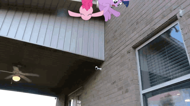 pinkie pie and twilight sparkle are hanging upside down on a brick building