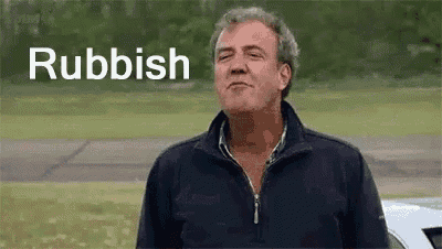 a man is standing in a field with a car in the background and the word rubbish is written on the screen .