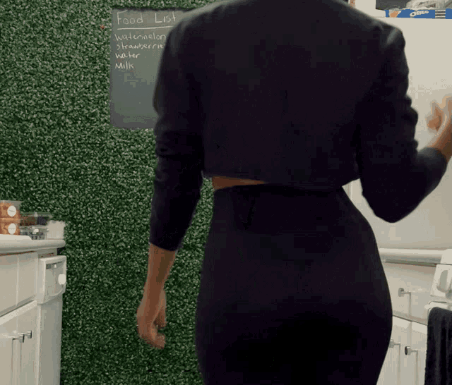 a woman stands in front of a chalkboard with the word food on it