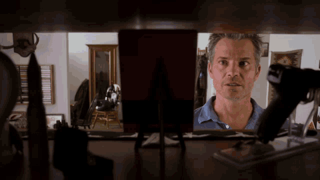 a man looking at himself in a mirror with a reflection of himself in the mirror