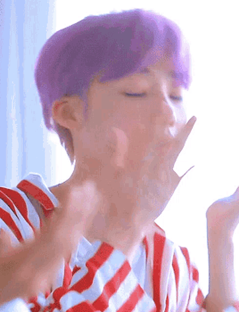 a person with purple hair is wearing a red and white striped shirt