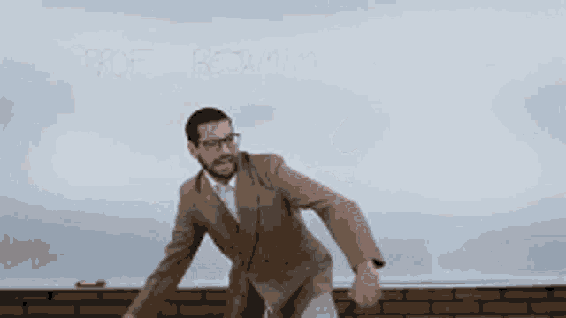 a man in a suit is standing in front of a whiteboard that says prof bedwin on it