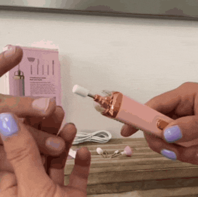 a woman holds a pink nail polisher in her hands