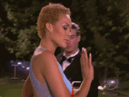 a woman in a blue dress is dancing with a man in a tuxedo