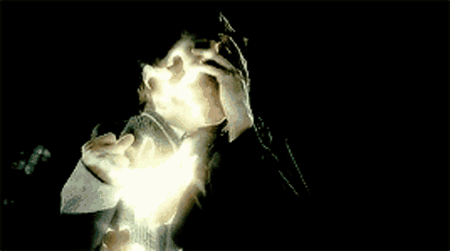 a close up of a person 's face with a glowing light behind them