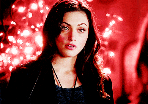a woman stands in front of a red background with lights
