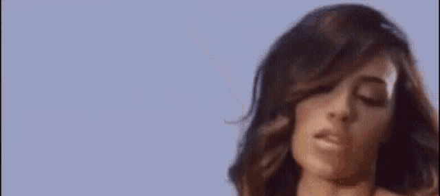 a close up of a woman 's face with a blue sky in the background .