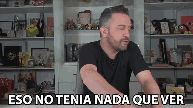 a man says eso no tena nada que ver in front of a shelf full of toys