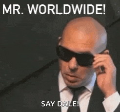 a bald man in a suit and tie is wearing sunglasses .