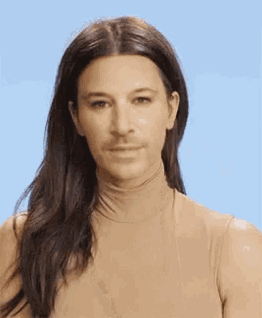 a woman with long hair and a fake mustache is wearing a tan turtleneck sweater .