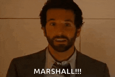 a man with a beard is holding his finger to his nose and saying `` marshal '' .