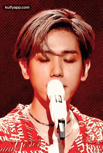 a close up of a person singing into a microphone .