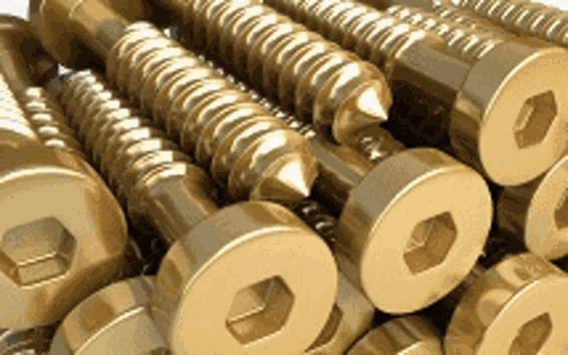 a bunch of brass screws are stacked on top of each other .