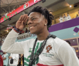 a man wearing a portugal / espana shirt salutes in a stadium