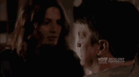 a man and a woman are looking into each other 's eyes in a room .
