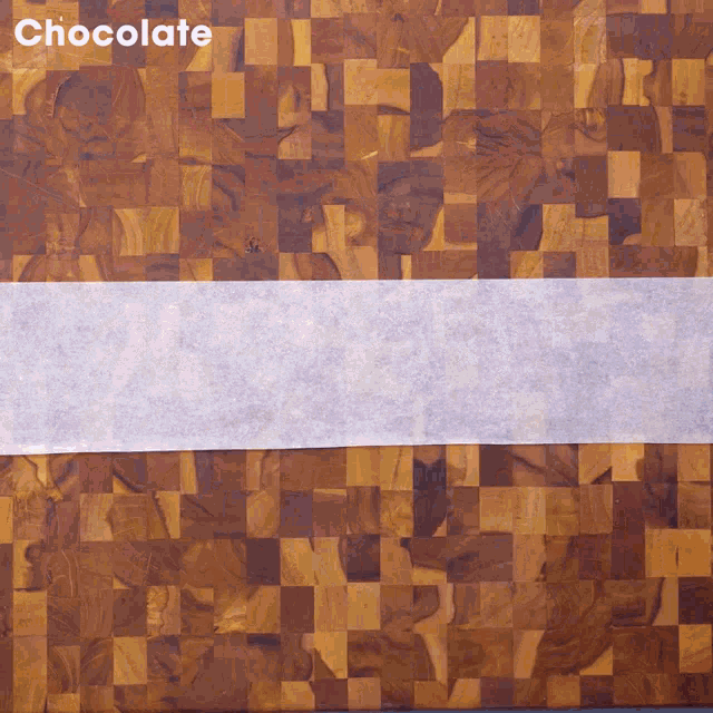 a wooden cutting board with a piece of wax paper on it that says chocolate