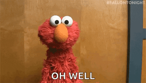 elmo from sesame street is standing in front of a wooden wall .