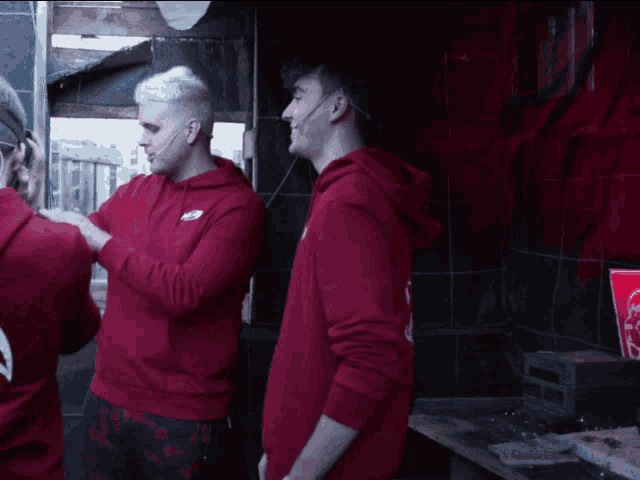 a man in a red hoodie with the word coca cola on the back