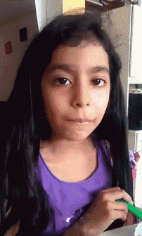 a little girl with long black hair is wearing a purple shirt and holding a green marker