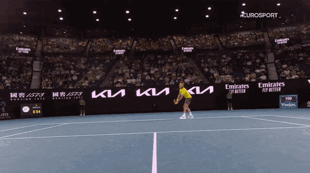 a tennis court with emirates fly better advertisements