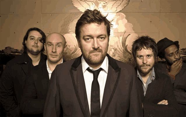 a group of men are posing for a picture with one man wearing a tie