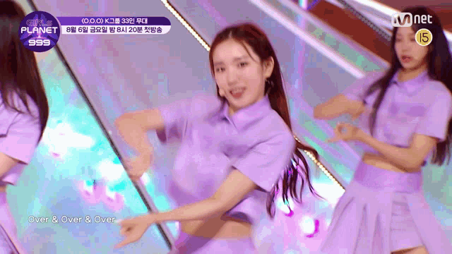 a girl in a purple shirt is dancing on a stage in front of a mnet logo .