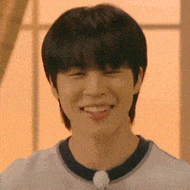 a close up of a young man smiling with his eyes closed and his mouth open .