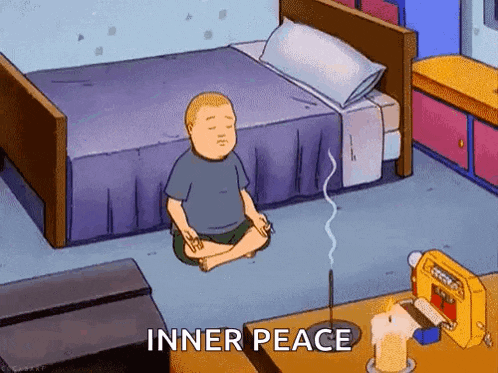 a cartoon character is sitting in a lotus position in front of a bed in a room .
