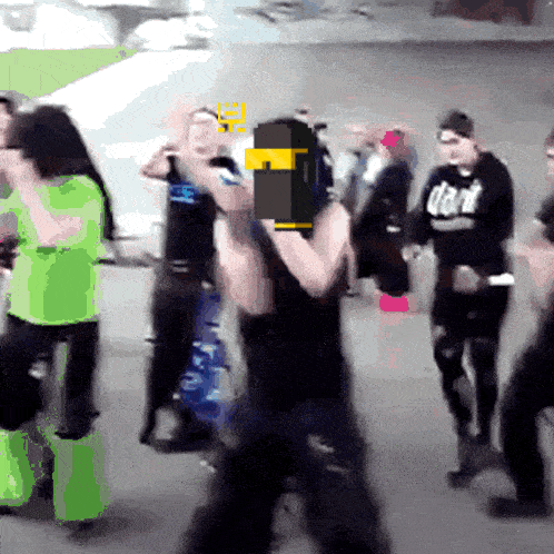 a man wearing a black shirt that says dark stands in a crowd