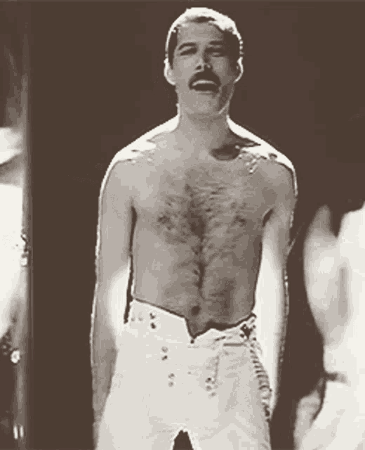 a shirtless man with a mustache is standing in front of a black background