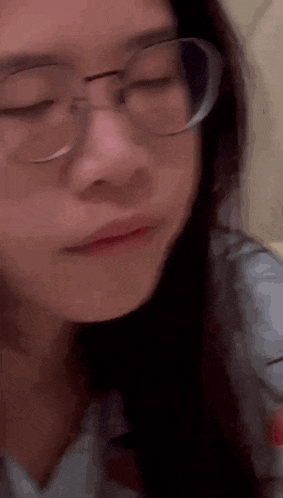 a close up of a woman wearing glasses making a face .