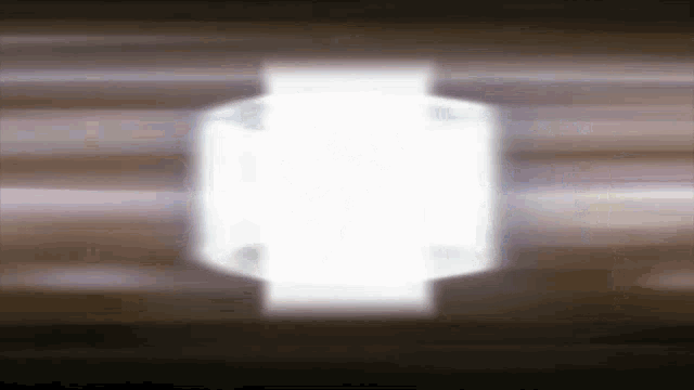 a blurred image of a light coming out of a hole in a wall