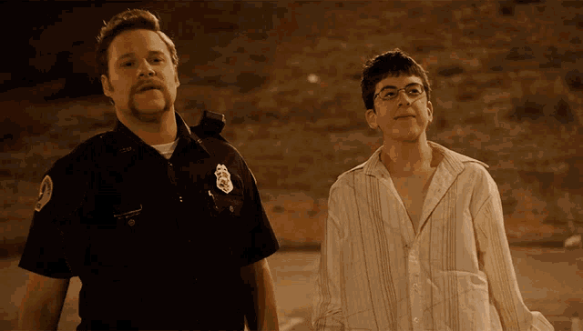 a police officer stands next to a young man