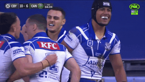 a group of rugby players wearing kfc jerseys celebrate