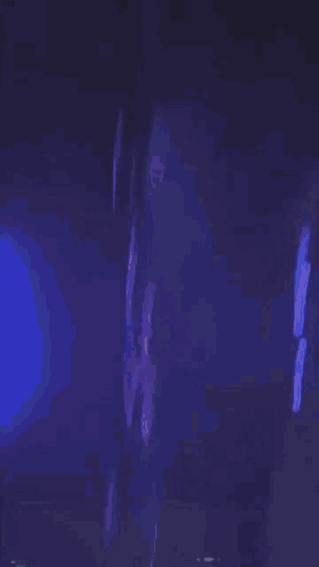 a blurry picture of a man in a white shirt in a dark room