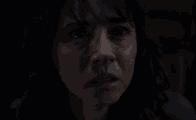a close up of a woman 's face with dark eyes