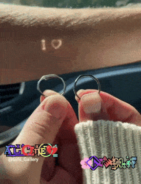 a couple holding their wedding rings in front of a car windshield with the words i love written on their wrist
