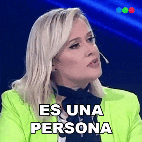 a woman in a neon green jacket is saying es una persona