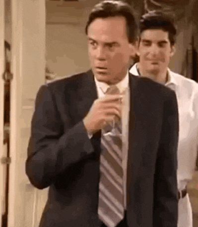 a man in a suit and tie is adjusting his tie .
