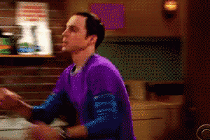 a man in a purple shirt is standing in a room