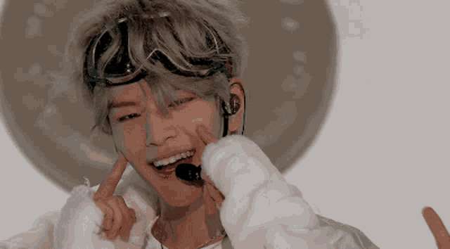 a young man wearing headphones and a microphone makes a funny face