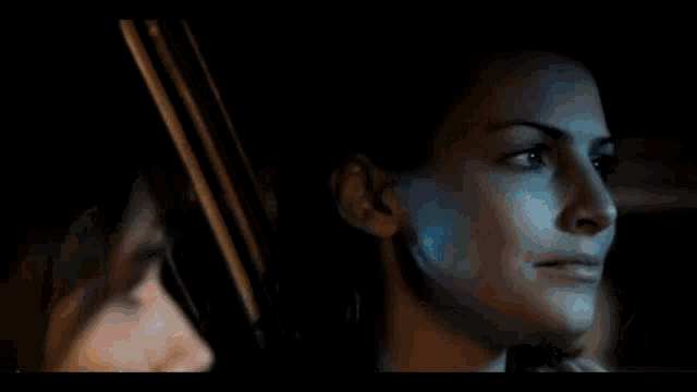 a woman is sitting in a car with a man and looking at him